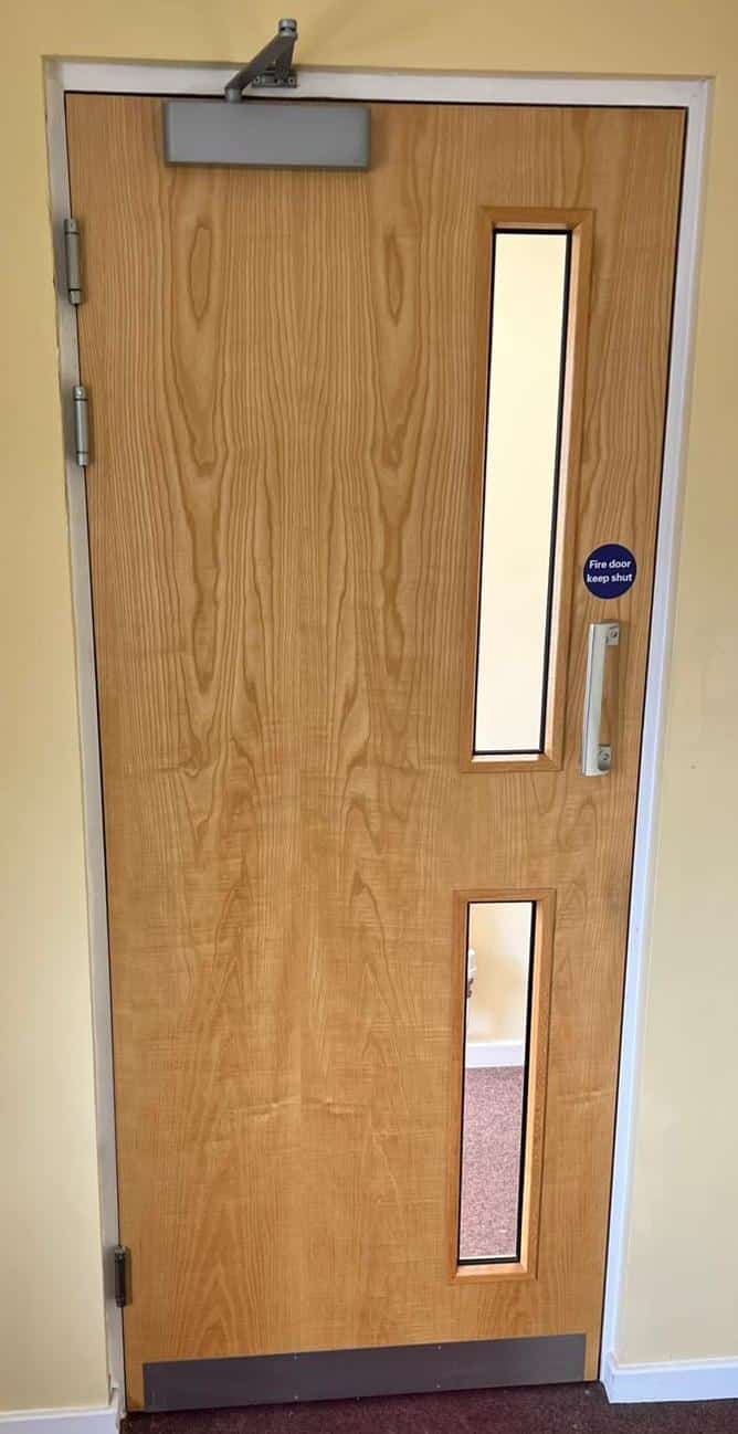 Wooden communal fire door with glass